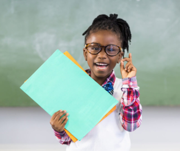 portrait-happy-schoolgirl-holding-file-classroom (1)