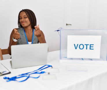 young-african-american-woman-working-political-election-sitting-by-ballot-doing-money-gesture-with-hands-asking-salary-payment-millionaire-business (1)